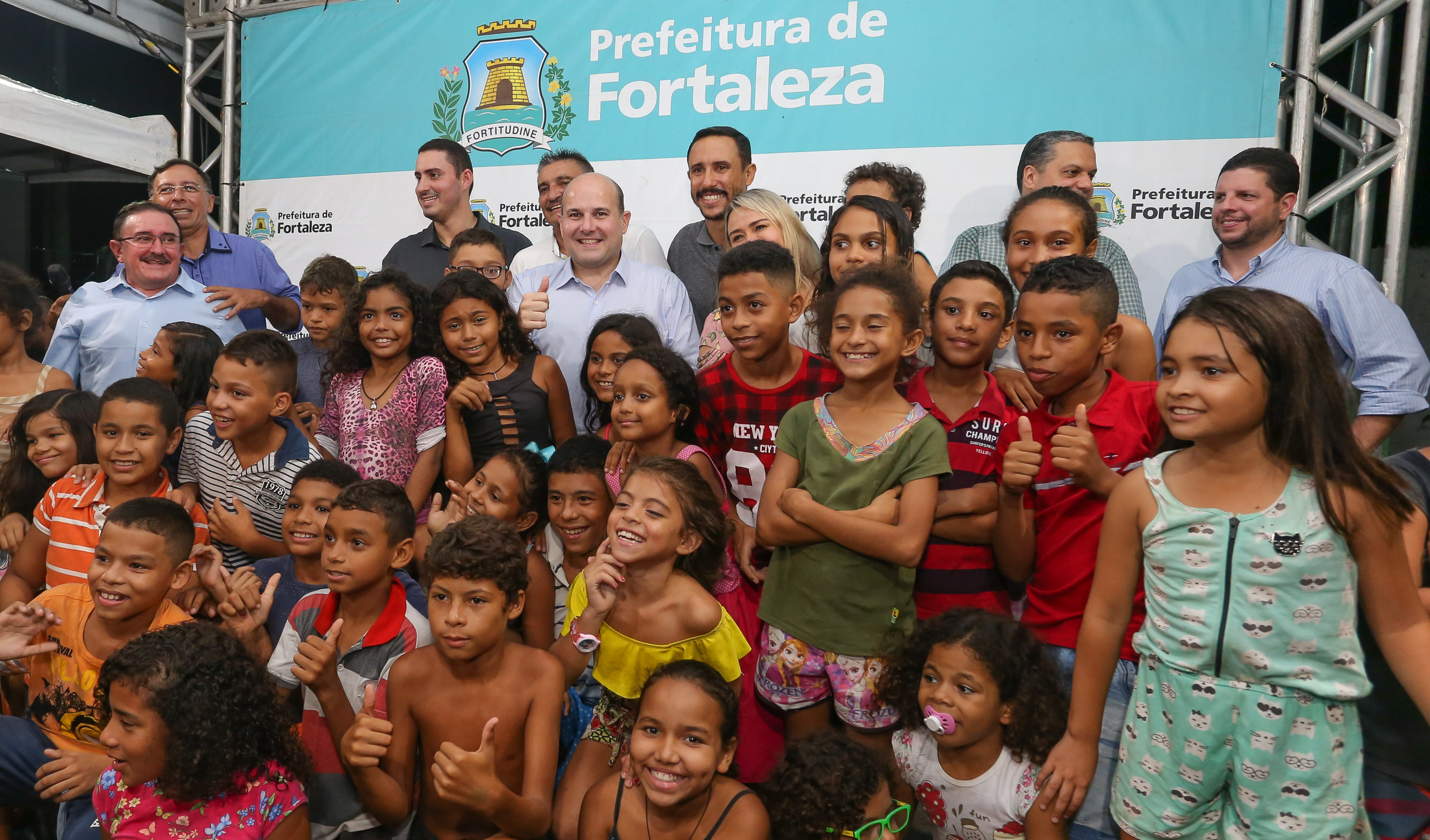 prefeito roberto cláudio posa para a foto cercado de crianças